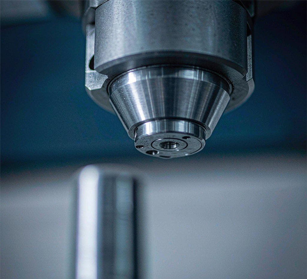 machinist inspecting used metalworking machinery with a precision dial indicator in a workshop
